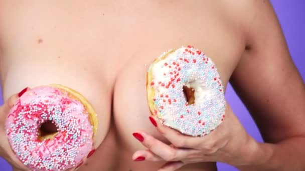 Close-up, donut e seios femininos. 4K, câmara lenta. donuts porno. donuts amante. Mulher sexy e Fast Food. Moda arte mínima — Vídeo de Stock