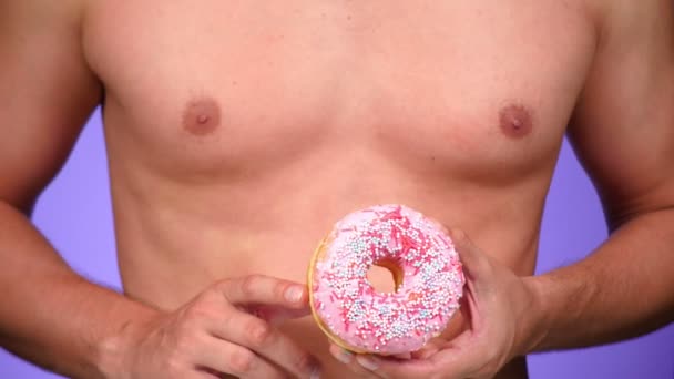 Close-up, donut e seios masculinos. 4K, câmara lenta. donuts porno. donuts amante. Homem sexy e Fast Food. Moda arte mínima — Vídeo de Stock