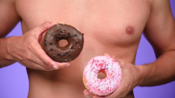 Yakın çekim, çörek ve erkek göğüsler. 4k, ağır çekim. çörek porno. Çörek sever. Fast Food ve seksi bir adam. Moda minimal sanat — Stok video