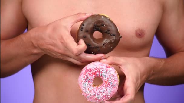 Close-up, donut e seios masculinos. 4K, câmara lenta. donuts porno. donuts amante. Homem sexy e Fast Food. Moda arte mínima — Vídeo de Stock