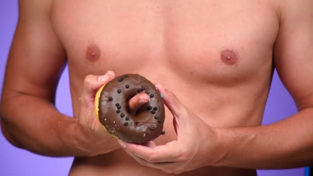 Närbild, donut och manliga bröst. 4k, slowmotion. Donuts porr. Donuts älskare. sexig man och snabbmat. Mode minimalistisk konst — Stockvideo