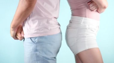 Kapatın. kalça. Genç seksi bir çift kavga bir açık mavi renkli, 4k, ağır çekim üzerinde moda görüntü