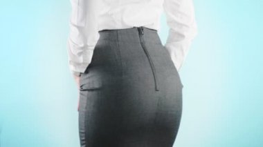 Renkli bir arka plan üzerinde güzel bir iş kadını. yakın çekim etek. kod elbise, kalça hareket. 4k, ağır çekim