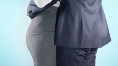 4 k. ağır çekim. Yakın çekim. Renkli arka plan. Bir işadamı ve bir iş kadını yan yana duruyor. Bir adam bir kadın dikkat belirtileri veriyor.