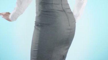 Renkli bir arka plan üzerinde güzel bir iş kadını. yakın çekim etek. kod elbise, kalça hareket. 4k, ağır çekim