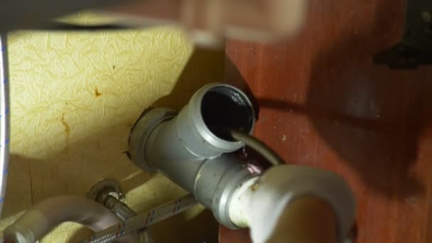 Installateur-Rohrleitungsreparaturen im Haus. Nahaufnahme. Der Installateur reinigt die Rohre mit Geräten. 4k, Zeitlupe — Stockvideo