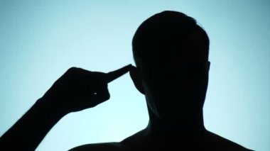 arka plan rengi. 4k, ağır çekim. bir insan gölgesi. adam jest gösterir. Twist olanlar parmak onun Tapınağı'nda