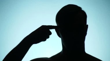 arka plan rengi. 4k, ağır çekim. bir insan gölgesi. adam jest gösterir. Twist olanlar parmak onun Tapınağı'nda