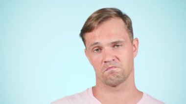 Mutlu adam. Bir fikri vardır. portre mavi zemin üzerine. 4 k, yavaş hareket, yakın çekim