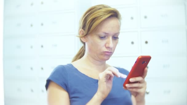 Женщина с телефоном ищет товар в магазине на складе. женщина использует свой смартфон. 4k — стоковое видео