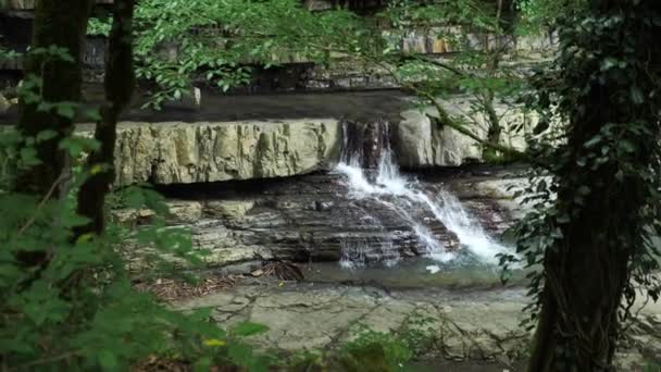 Naturaleza escénica de una hermosa cascada y esmeralda de un lago de agua dulce en un entorno selvático salvaje. 4k, cámara lenta — Vídeo de stock