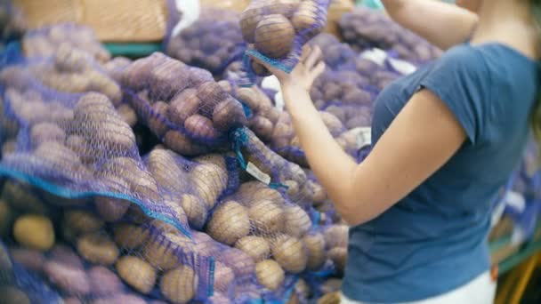 Женщина в супермаркете покупает овощи, картошку — стоковое видео