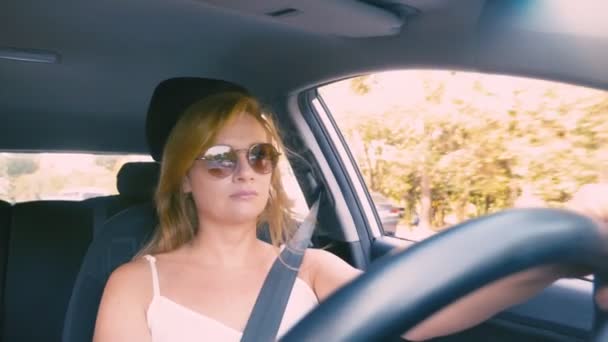 車を運転してのサングラス幸せな美しい金髪の女性。4 k、スローモーション. — ストック動画