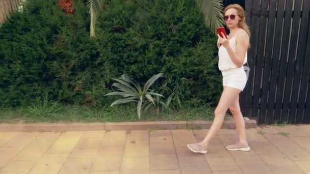 Benadrukt dat de vrouw praten over de telefoon op straat, met een nerveuze gesprek, gevoel pijn en hoofdpijn. Steadicam geschoten. 4k, slow-motion-video schieten — Stockvideo