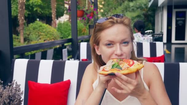 Bella giovane donna che mangia una fetta di pizza al bar. primo piano, 4k, rallentatore — Video Stock
