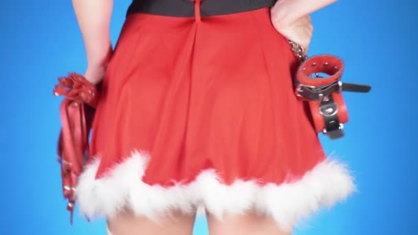 Sedutor santa menina com brinquedos sexuais em poses sedutoras. num fundo azul. um close-up. Movimento lento. 4k — Vídeo de Stock