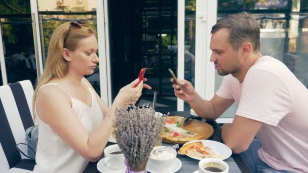 在室外咖啡馆的情侣。男人和女人约会。一个合伙人看着他的手机, 第二次试图和他说话。4k. 慢动作. — 图库视频影像
