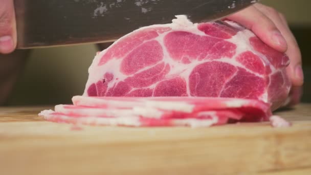 男は、スローモーションでナイフで生の肉をカットします。4 k、クローズ アップ — ストック動画