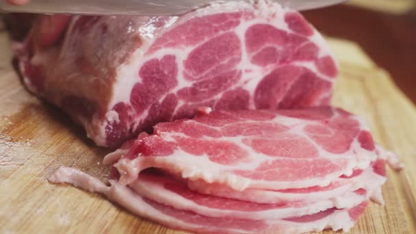 Egy férfi csökkenti a nyers hús lassítva késsel. 4k, közeli — Stock videók