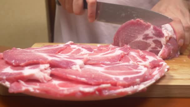 A man cuts raw meat with the knife in Slow Motion. 4k, close-up — Stock Video