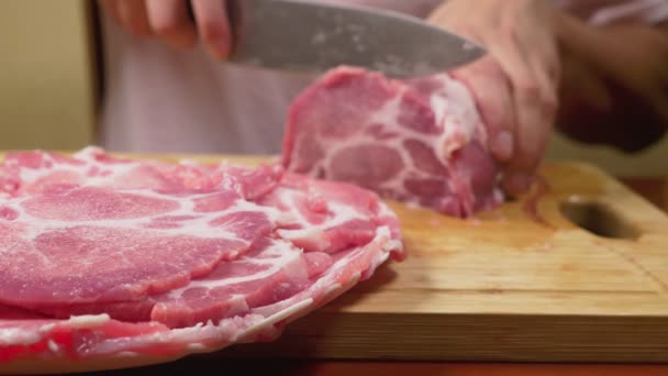 A man cuts raw meat with the knife in Slow Motion. 4k, close-up — Stock Video