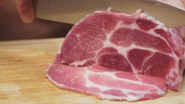 bir adam ağır çekimde bıçakla çiğ et keser. 4k, yakın çekim