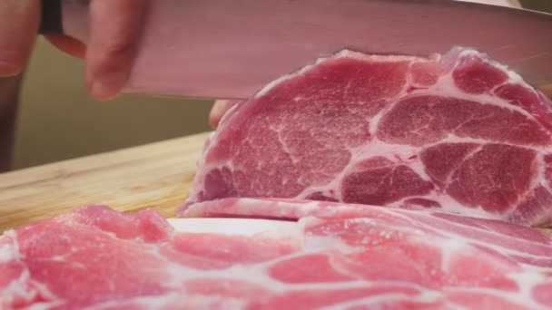 Ένας άνθρωπος κόβει ωμό κρέας με το μαχαίρι σε αργή κίνηση. 4k, γκρο πλαν — Αρχείο Βίντεο