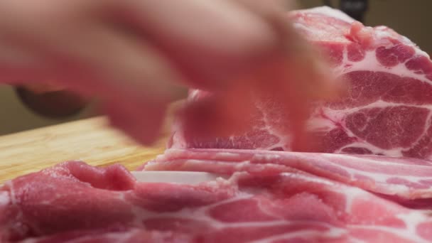 Un hombre corta carne cruda con el cuchillo en cámara lenta. 4k, primer plano — Vídeo de stock