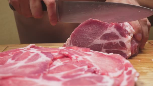 Ένας άνθρωπος κόβει ωμό κρέας με το μαχαίρι σε αργή κίνηση. 4k, γκρο πλαν — Αρχείο Βίντεο