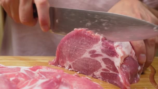 A man cuts raw meat with the knife in Slow Motion. 4k, close-up — Stock Video