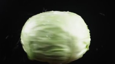 cabbagehead, - kadar yakın. Siyah bir arka plan üzerinde dönen bir elma üzerinde su damlacıkları kalmaktadır. süper ağır çekim.