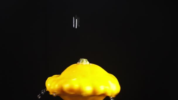 Squash, hautnah. Wassertropfen fallen auf einen rotierenden Apfel auf schwarzem Hintergrund. Superzeitlupe. — Stockvideo