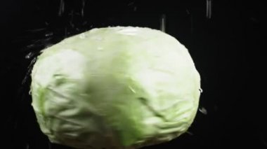 cabbagehead, - kadar yakın. Siyah bir arka plan üzerinde dönen bir elma üzerinde su damlacıkları kalmaktadır. süper ağır çekim.