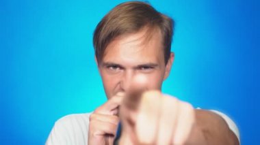 deli, komik ve genç bir adam, bir mikrofona şarkı söylüyor. renkli arka planı, yakın çekim. 4k, ağır çekim