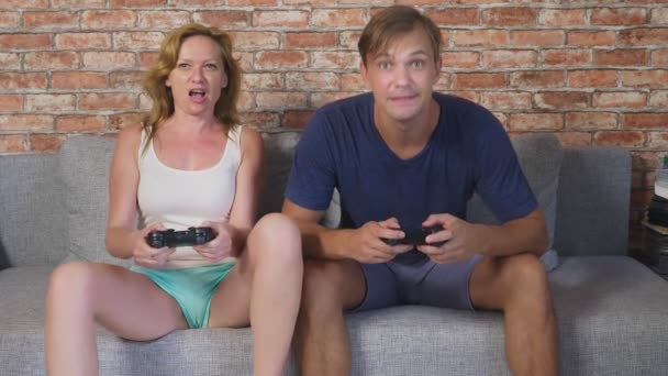 Emocional Homem e mulher Joysticks jogar no console, eles competem e fazer caras estranhas loucas. 4k, câmera lenta — Vídeo de Stock