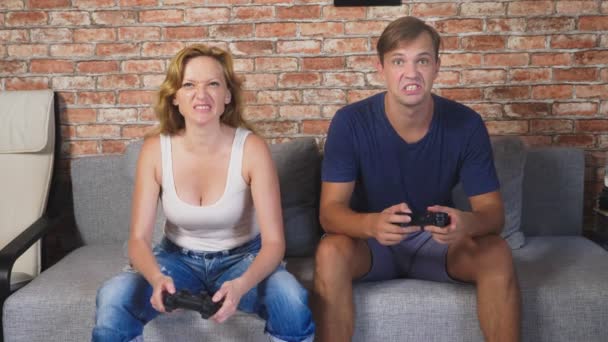 Emotivo uomo e donna Gioca Joystick in The Console, competono e fanno facce folli divertenti. 4k, rallentatore — Video Stock