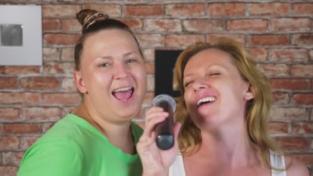 Κλείστε. δύο γυναίκες ούρλιαζε στο μικρόφωνο. μια γυναίκα τραγουδάει καραόκε στο σπίτι ένα μικρόφωνο. 4k, αργή κίνηση — Αρχείο Βίντεο