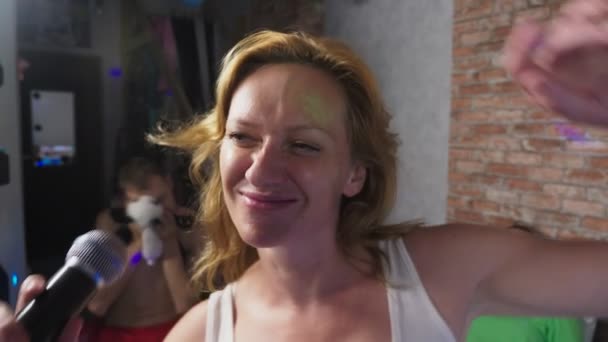 Ferme là. une femme criant à un micro. une femme chante du karaoké dans un micro dans un cadre familial. 4k, au ralenti — Video