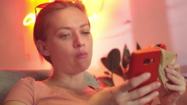 Kız retro bir kafede kahve bisküvi ile içme ve onun telefon üzerinden tarama. 4 k. ağır çekim