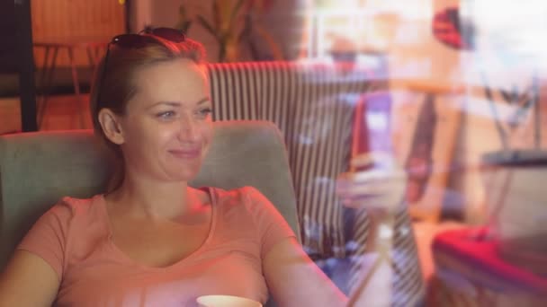Flickan är dricka kaffe med ett kex i en retro café och bläddrar i sin telefon. 4 k. slowmotion — Stockvideo