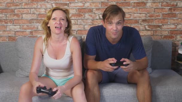 Emotional Man And Woman Play Joysticks in The Console, they compete and make crazy funny faces. 4k, slow motion — Stock Video