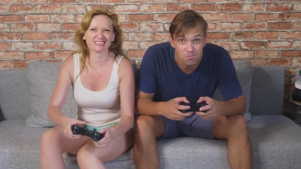 Emotivo uomo e donna Gioca Joystick in The Console, competono e fanno facce folli divertenti. 4k, rallentatore — Video Stock