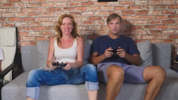 Hombre emocional y la mujer juegan Joysticks en la consola, compiten y hacen caras divertidas locas. 4k, cámara lenta — Vídeos de Stock