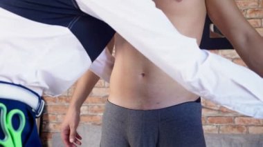 moda tasarımcısı giysi, şortlu genç bir adamdan ölçümler almak. mizah, ironi. 4k, ağır çekim silah, stadikam atış