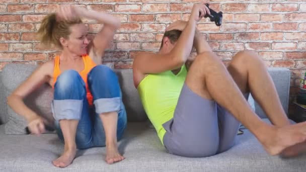 Эмоциональный мужчина и женщина играют Joysticks в консоли, они конкурируют и делают сумасшедшие смешные лица. 4k, slow motion — стоковое видео