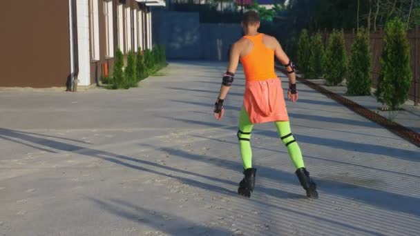 Sexy happy guy in bright clothes, doing poses on his roller skates. Slow video, 4k, standicam shot — Stock Video