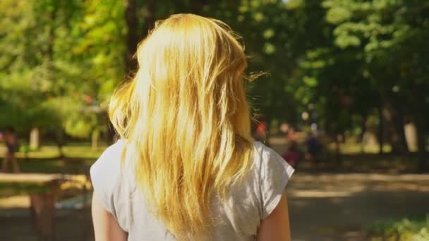 晴れた日に セグウェイに乗って白いパンツの女の子 公園の夏し 太陽のまぶしさ スローモーション撮影 Stadikam ショット — ストック動画