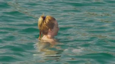 kalıcı makyaj dinlenme olmadan bir kadın. Bir kızın sırtında bir şişme yastık üzerinde yalan denizde yüzüyor. 4 k yavaş hareket