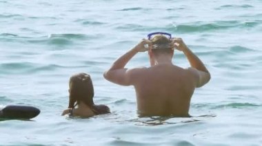 Denizde yüzme mutlu bir aile. Tatil ve seyahat kavramı. 4k, ağır çekim