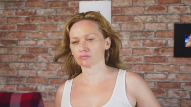 yakın çekim. 4 k. ağır çekim. Bir tuğla duvar rüzgar saçlarını üfleme önünde bir kadın portresi.